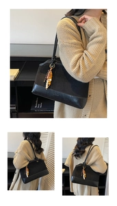 Détail du sac cabas en daim noir avec bordure en cuir et porte-clés en bois coloré