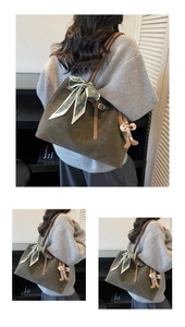 Close-up of a green suede tote bag featuring a floral scarf handle and cute animal charm