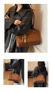 Détail du sac fourre-tout en daim marron et cuir avec breloque en perles de bois