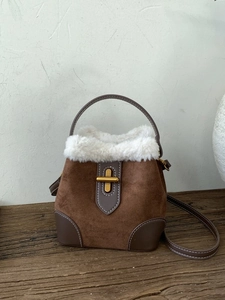 Sac seau en cuir givré marron avec garniture en peluche blanche et fermoir doré sur bois