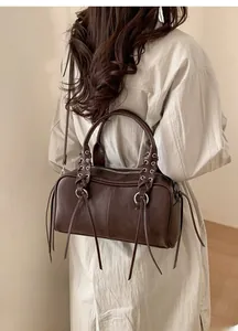 Detail of vintage brown leather bag with metallic ring and stylish long tassel fringes