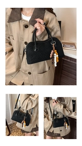 Détails du sac à main noir tressé avec pompon en perles et diverses options de transport