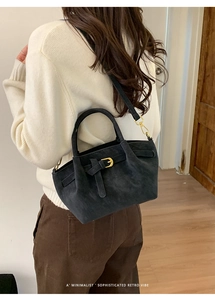 Detail of dark grey suede tote bag with golden metal buckle and minimalist retro vibe