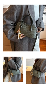 Détail du sac tressé vert foncé avec pompon en perles de bois et bandoulière réglable