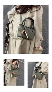 Detail view of square bucket bag with textured pattern and decorative bead charm
