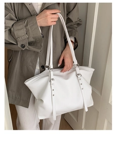 Close-up of white lychee pattern leather tote bag showing double straps and metal eyelets