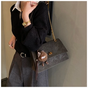 Detail of grey frosted satchel with gold twist lock and leopard bow monster charm
