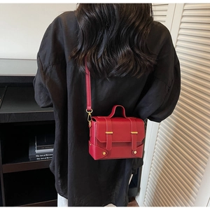 On-body view of a vintage red crossbody bag showing real-life proportions and matte finish