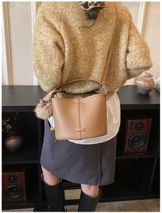 Brown leather bucket bag with leopard scarf detail worn on casual knitted sweater