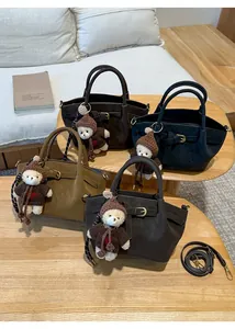 Collection of four suede bucket bags in earthy tones featuring teddy bear charms