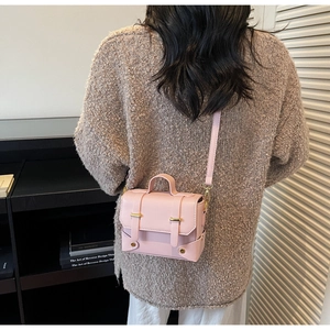 Detail of pink vintage crossbody square bag shown as a back view on a model