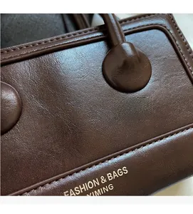 Macro detail of dark brown leather texture and decorative studs on baguette handbag