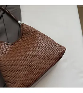 Detail of brown woven hobo bag showing intricate texture and silver metal hardware