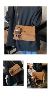 Detail of vintage brown frosted messenger bag with gold lock and plush sheep charm
