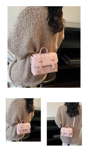 Detail view of light pink square handbag with gold hardware and leather strap