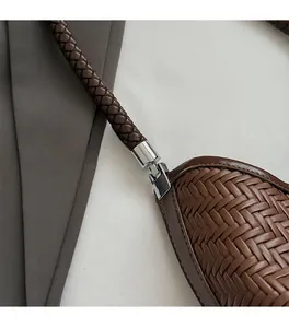 Detail of dark brown woven leather bag featuring premium silver metallic hardware