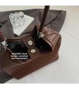 Close-up of the magnetic buckle closure and woven texture on a brown hobo bag