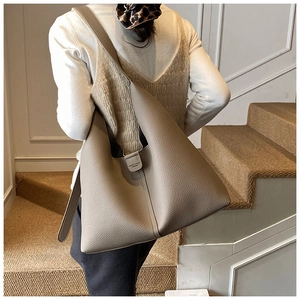 Detailansicht der grauen Shopper-Tasche aus Leder mit Fokus auf Textur und Schultergurt