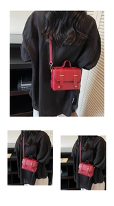 Detailed view of red mini square bag with vintage gold buckle and leather texture