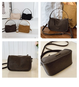 Detail of the retro hobo bag showing the high-quality matte leather and metal logo plaque
