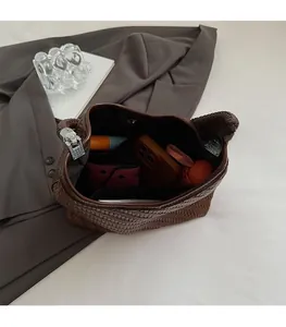 Macro shot of spacious dark brown woven bucket bag showing interior storage capacity