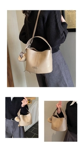 Detail of beige lychee leather bucket bag with leopard bow and plush ball charm accessory