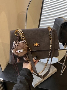 Deep grey frosted leather crossbody bag with gold chain and plush monster charm