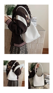 Detail of white woven hobo bag showing intricate V-pattern texture and broad strap