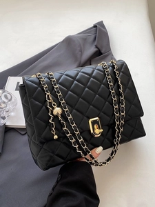 Quilted black crossbody bag with gold chain strap and spherical charm detail