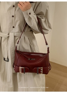 Sophisticated retro burgundy tote bag with silver buckle details worn with a beige trench coat