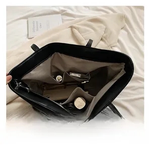 Macro view of the spacious inner compartments of this black Oxford tote bag with organizer