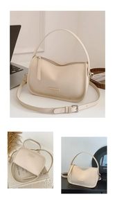 Detail of cream leather handbag showing metal zipper and adjustable shoulder strap