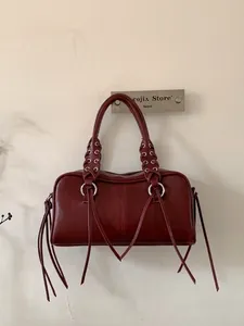 Dark red leather motorcycle underarm bag with woven handles and long decorative fringes