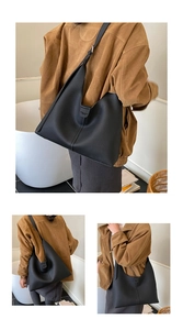 Detail der schwarzen Hobo-Tasche aus Kieselleder mit Logoprägung und robustem Schultergurt