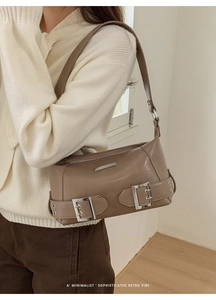 Detail of retro mocha shoulder bag with polished synthetic leather and silver buckle