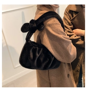 Détail du sac à main noir en peluche avec bandoulière nouée et texture douce et élégante