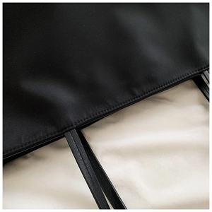 Detail of durable black nylon fabric with premium stitching and leather handle texture