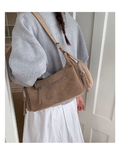 Detailed side view of a brown suede crossbody bag with metallic silver zipper details