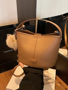 Chic khakis lychee pattern bucket bag with plush charm and leopard scarf accent