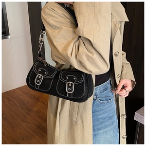 Close-up of black shoulder bag with white contrast stitching and metallic H-buckle