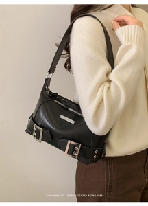 Detail of retro black leather tote bag with silver metallic hardware and buckle straps