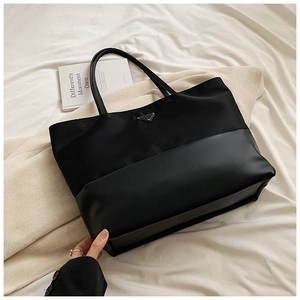 Detail of black tote bag with nylon and leather patchwork and triangular logo