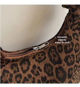 Detail of leopard print underarm bag featuring a smooth silver metal zipper closure