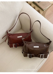 Deep red and brown vintage baguette bags in shiny oil wax leather on a white sofa