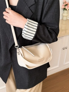 Chic cream white crossbody bag with silver hardware shown on a female model