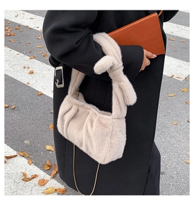 Détail du sac bandoulière en peluche marron avec poignée nouée et chaîne dorée