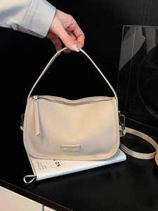 Chic beige crossbody bag with silver chain strap and minimalist semi-circular design