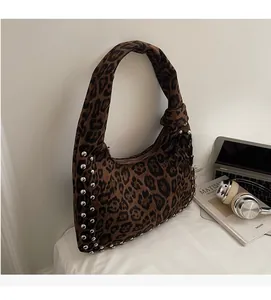 Detail view of leopard print underarm bag with silver studs and knotted handle design