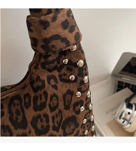 Detail of leopard print tote bag with silver metal studs and knotted handle design