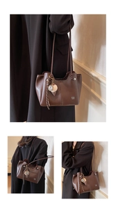 Close-up of large coffee brown leather tote with fine straps and ice cream charm